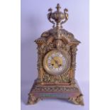 A 19TH CENTURY FRENCH BRASS MANTEL CLOCK the top surmounted with a twin handled urn, the case