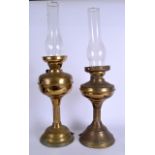 TWO EARLY 20TH CENTURY BRASS OIL LAMPS, on pedestal base with associated glass funnel. Largest 59