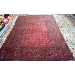 A RED GROUND AFGHAN RUG,decorated with symbols.277 cm x 200 cm.