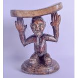 AN EARLY 20TH CENTURY AFRICAN CARVED HARDWOOD TRIBAL FERTILITY HEAD REST modelled as a female