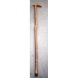 A CARVED EARLY 20TH CENTURY WALKING STICK, with rhinoceros horn handle. 87 cm long.