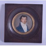 AN EARLY 19TH CENTURY PAINTED IVORY PORTRAIT MINIATURE depicting a male wearing a blue jacket. Image