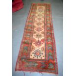 AN ANTIQUE CAUCASION RUNNER, decorated with symbols. 253 cm x 76 cm.