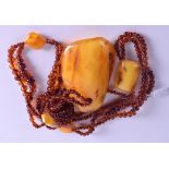 A GOOD CARVED AMBER NECKLACE. Overall 172 grams. Pendant 9.75 cm x 6.5 cm.