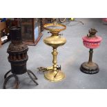 AN UNUSUAL RUSTIC WOODEN LAMP WITH HORSE SHOE FEET, together with two other oil lamps. Largest 54 cm