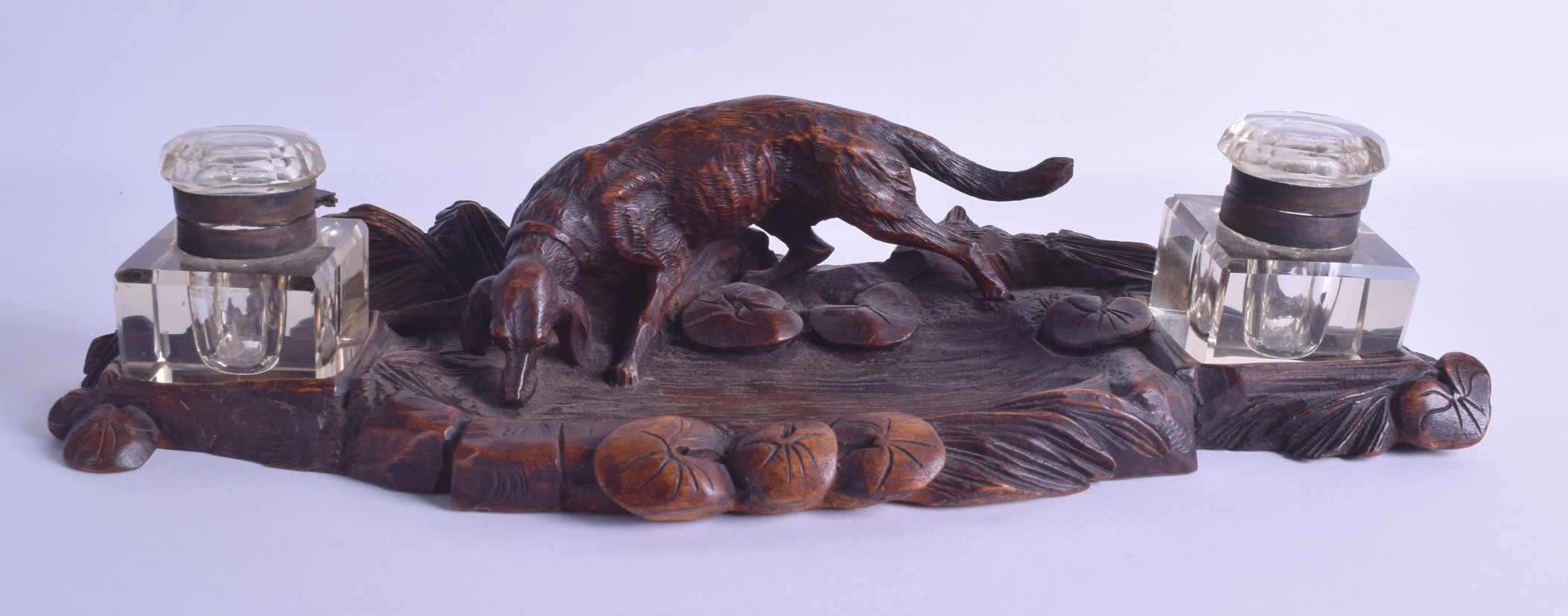 A LATE 19TH CENTURY BAVARIAN BLACK FOREST CARVED INKWELL modelled with a hound drinking water from a