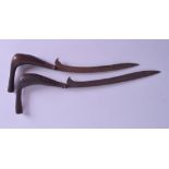 A NEAR PAIR OF 19TH CENTURY MIDDLE EASTERN KRISS TYPE DAGGERS one with copper handle. 36 cm & 31