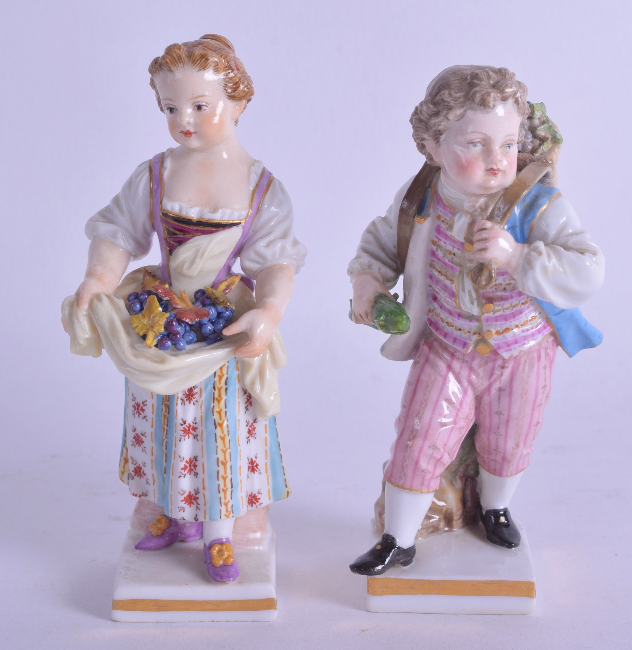 A SMALL PAIR OF 19TH CENTURY MEISSEN PORCELAIN FIGURES modelled as a female holding berries, the