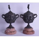 A LARGE PAIR OF 19TH CENTURY FRENCH TWIN HAN DLED BRONZE URNS AND COVERS decorated with classical