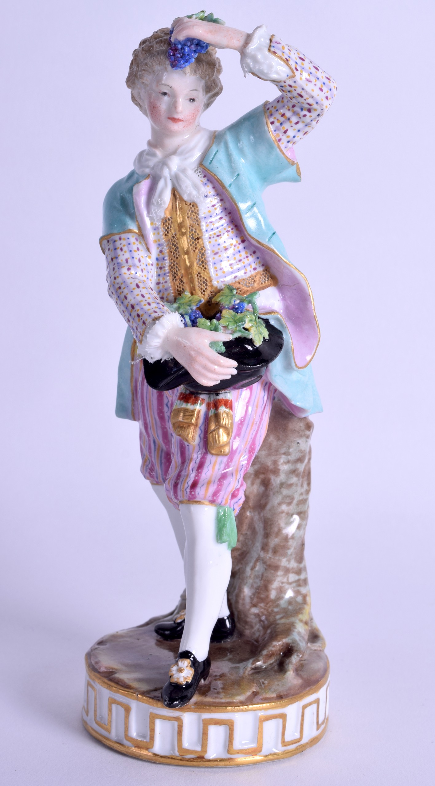 19th c. Meissen figure of a boy holding grapes in his hand and hat wearing striped pantaloons