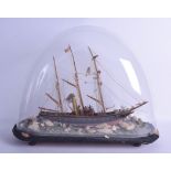 A RARE ANTIQUE FOLK ART SHELL DECORATED SHIP under a glass dome, modelled with several attendants on