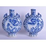 A PAIR OF 19TH CENTURY CHINESE BLUE AND WHITE TWIN HANDLED MOON FLASKS painted with figures,