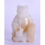 AN UNUSUAL CHINESE CARVED WHITE JADE FIGURE OF A SEATED BEAR modelled in robes holding a vessel. 5.