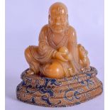 AN EARLY 20TH CENTURY CHINESE CARVED SOAPSTONE FIGURE OF A BUDDHA modelled beside a buddhistic