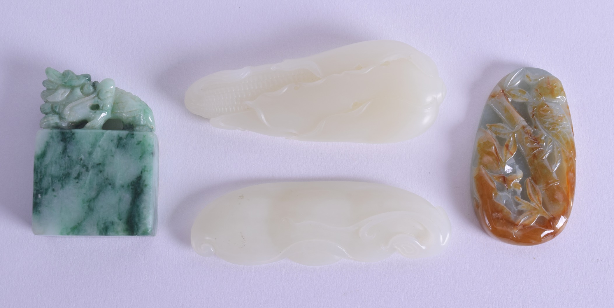 TWO CHINESE CARVED GREENISH WHITE JADE FLORAL AMULETS Late Qing, together with a jadeite seal &