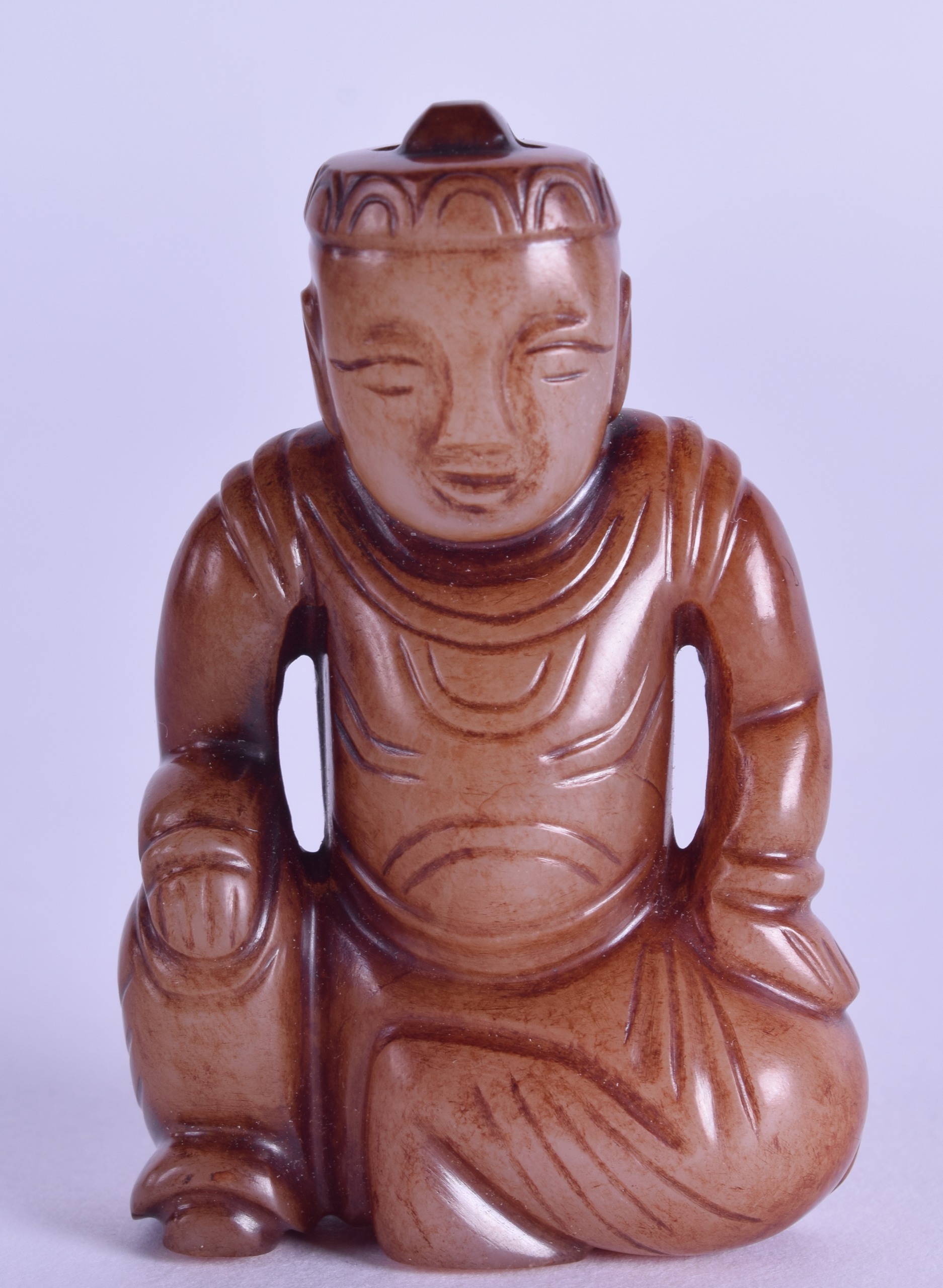 A SMALL CHINESE CARVED RUSSET JADE FIOGURE OF A SEATED MALE modelled in robes. 5.75 cm high.