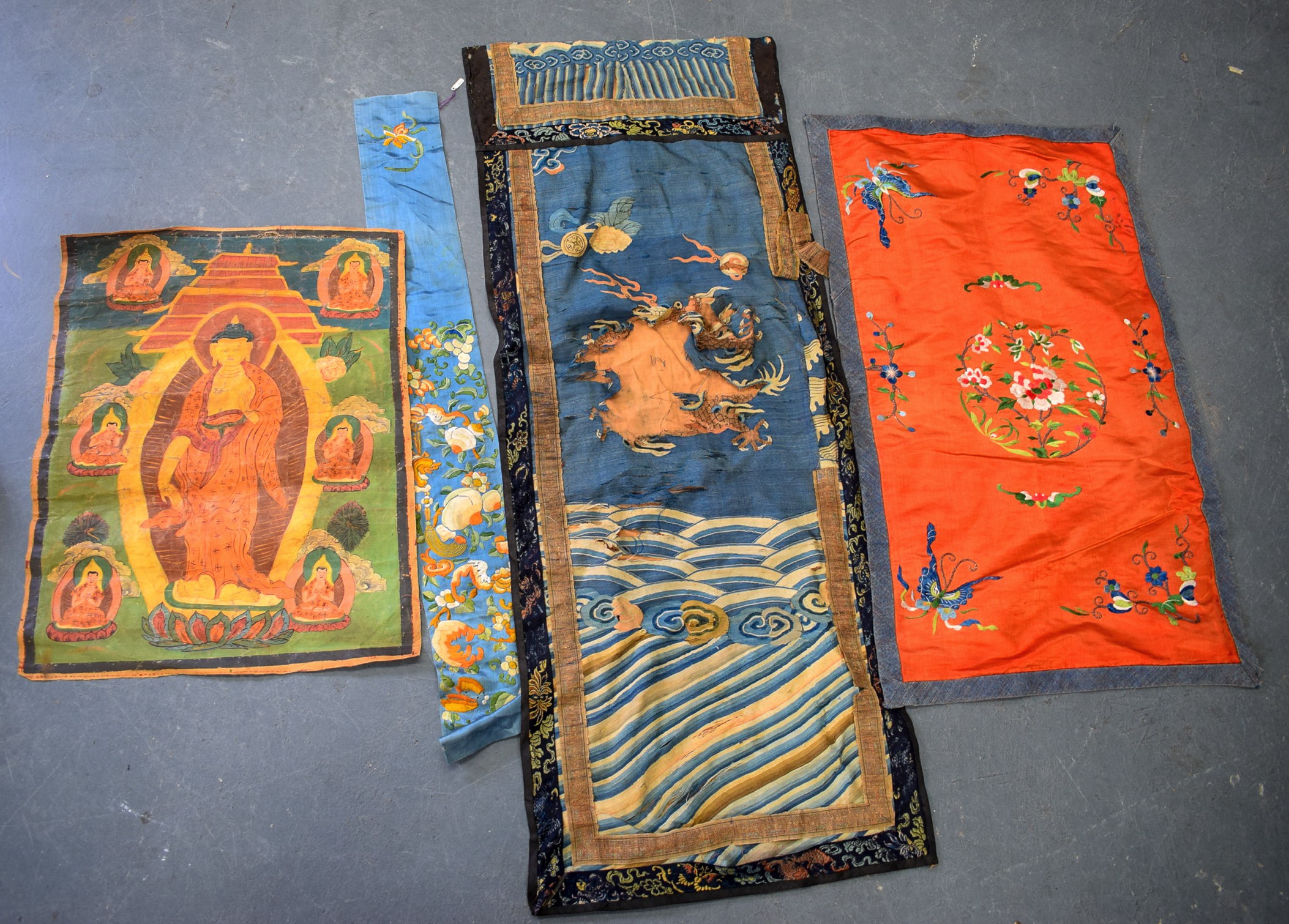 A 19TH CENTURY CHINESE BLUE GROUND EMBROIDERED SILK PANEL, together with a Thangka and two other