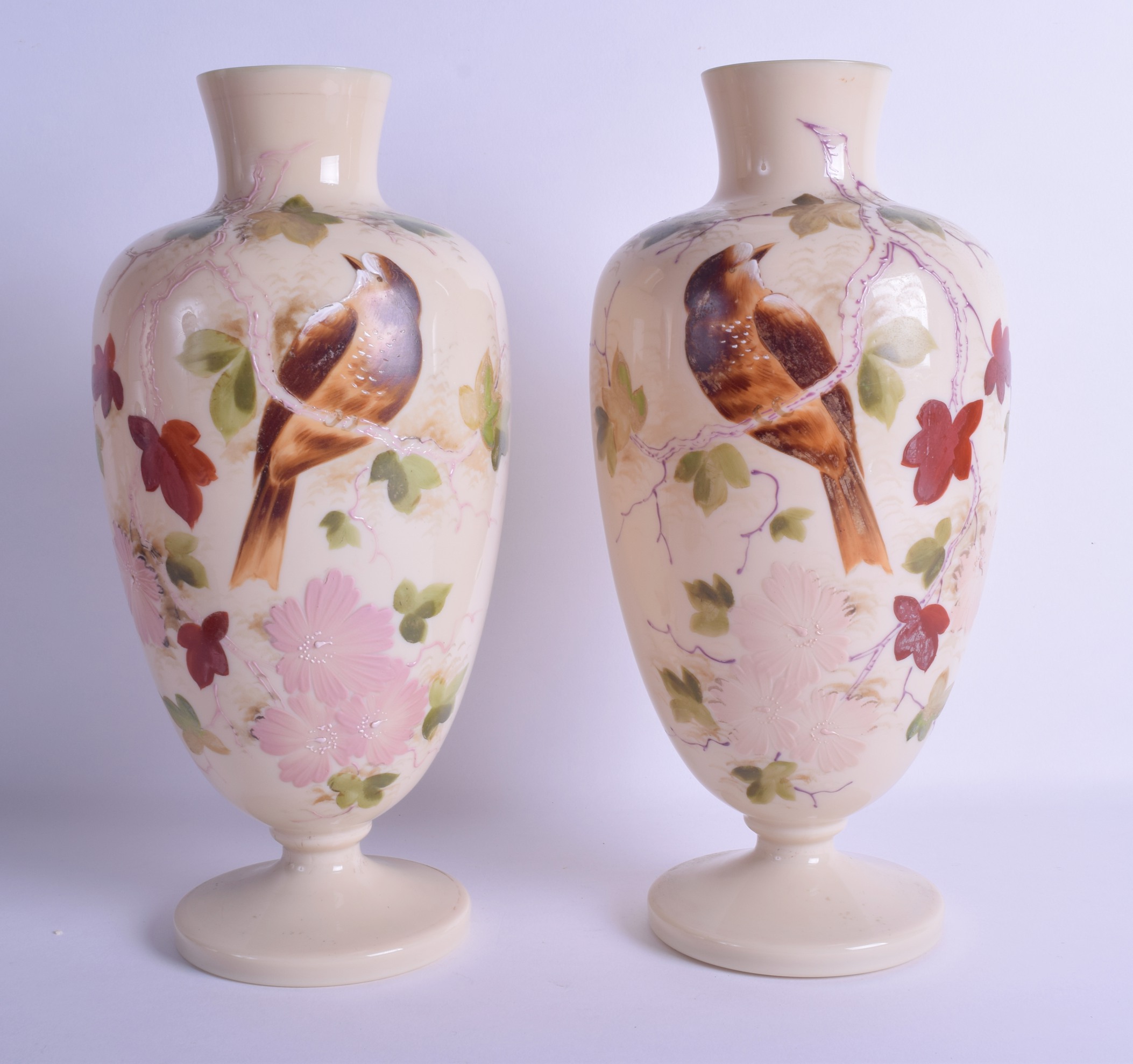 A PAIR OF LATE VICTORIAN ENAMELLED OPALINE GLASS VASES painted with birds perched amongst foliage.