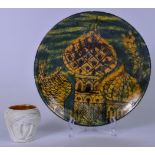 A MIDDLE EASTERN POTTERY DISH PAINTED WITH A BUILDING, together with a character jug in the form