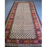 A RED GROUND RUG, decorated with stylised flowers. 350 cm x 165 cm.
