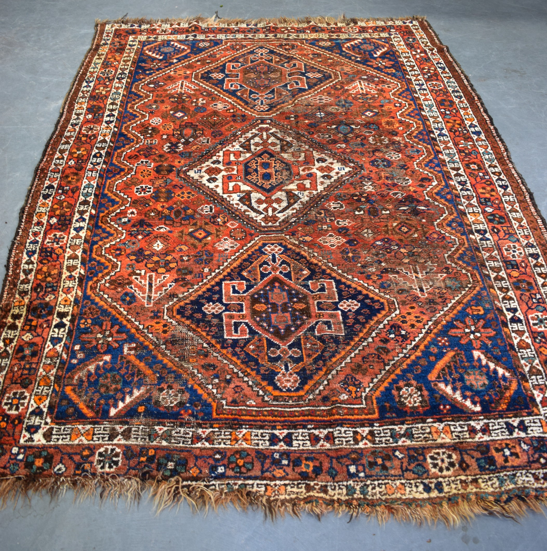 A BLUE GROUND PERSIAN RUG, decorated with symbols and motifs. 247 cm x 169 cm.