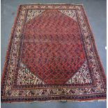 A RED GROUND PERSIAN RUG, decorated with symbols and motifs. 178 cm x 125 cm.