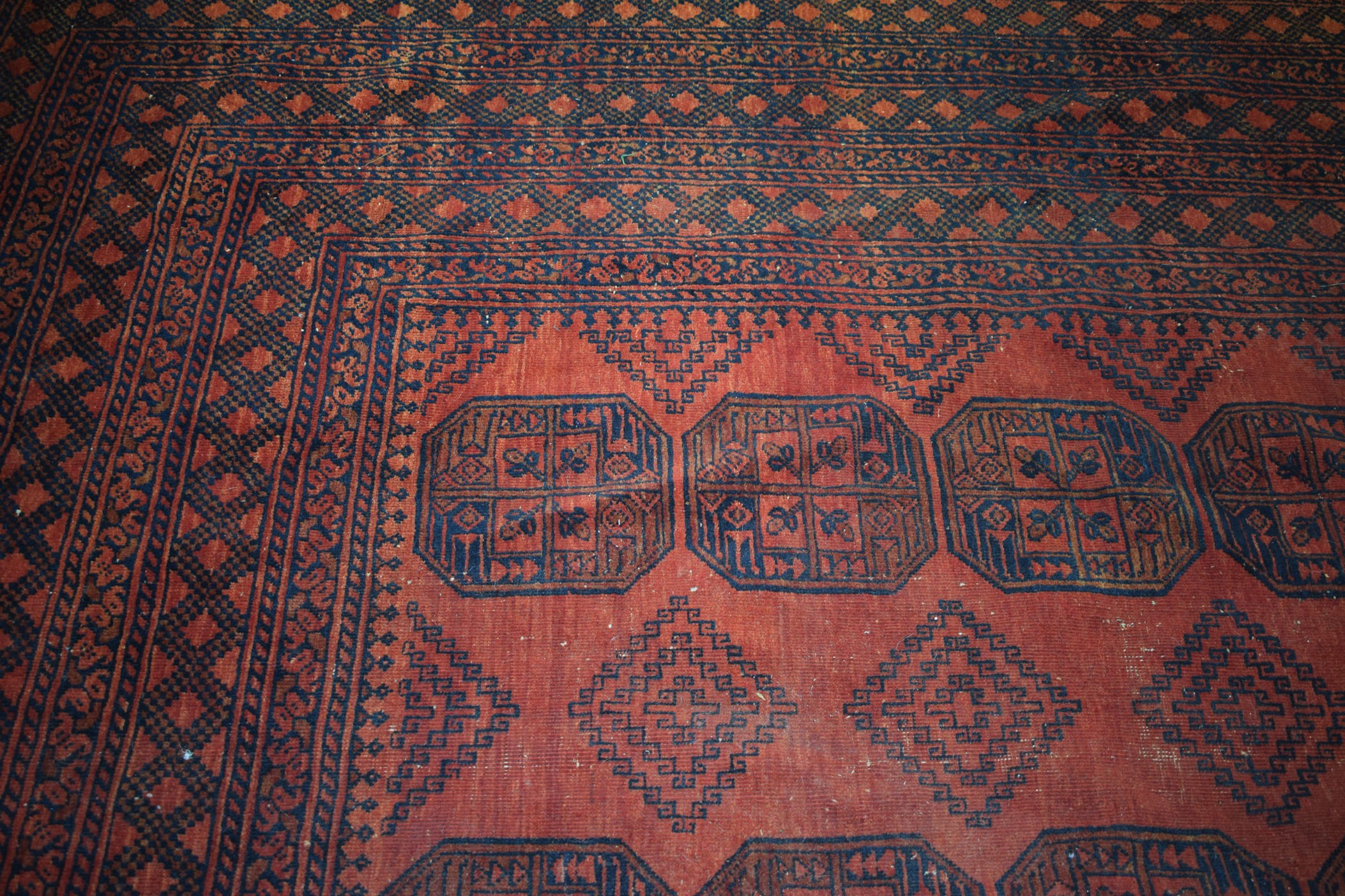 A LARGE EARLY 20TH CENTURY BURNT ORANGE GROUND AFGHAN ESARI TURKMEN RUG, decorated with motifs. - Image 3 of 5