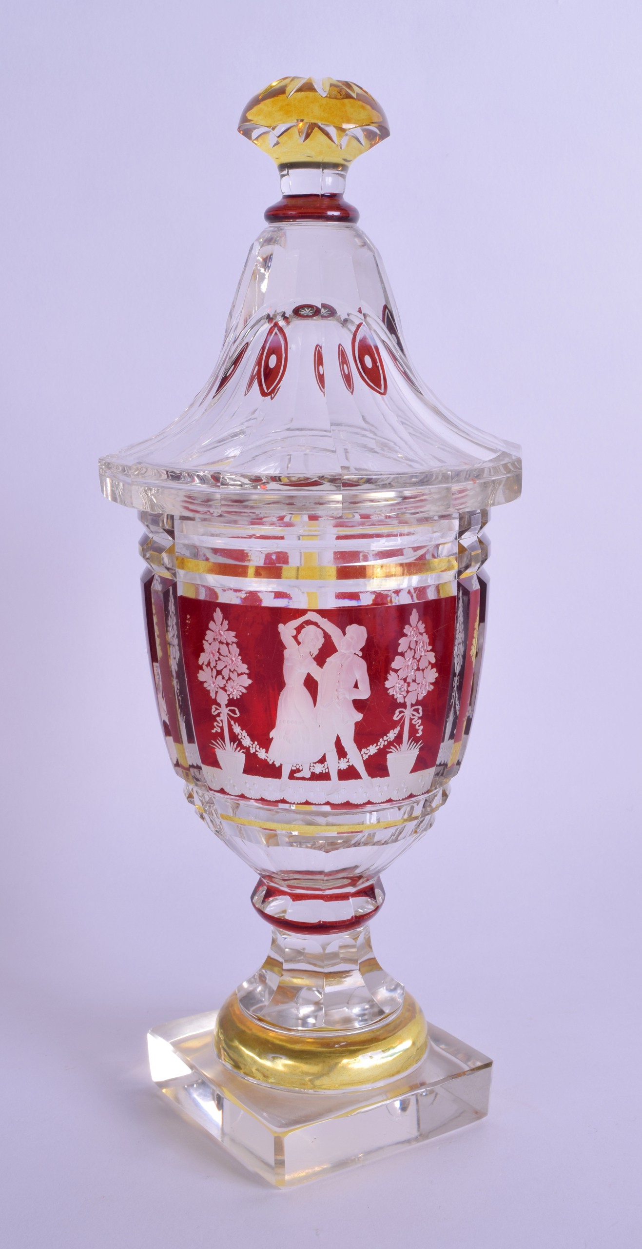 A 19TH CENTURY BOHEMIAN RUBY YELLOW AND CLEAR GLASS VASE AND COVER decorated with figures within