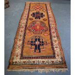 A BROWN GROUND PERSIAN RUNNER, decorated with symbols and motifs. 310 cm x 103 cm.