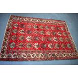 A RED GROUND PERSIAN RUG, decorated with a motifs. 185 cm x 134.