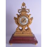 A GOOD EARLY 19TH CENTURY FRENCH ORMOLU MANTEL CLOCK decorated with floral decoration, upon a red