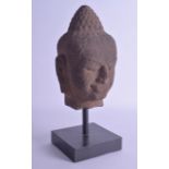 AN EARLY SOUTH EAST ASIAN CAMBODIAN CARVED STONE HEAD modelled as an aggressive male buddha. Head 21