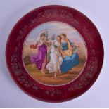 A LARGE EARLY 20TH CENTURY VIENNA PORCELAIN CIRCULAR CHARGER painted with three figures under a