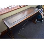 AN EARLY 20TH CENTURY WOODEN WINDOW BENCH, carved foliate type border. 119 cm wide.