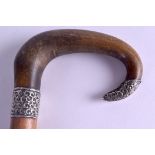 A 19TH CENTURY CARVED RHINOCEROS HORN WALKING CANE with silver mounts to ferrule and tip. 90 cm