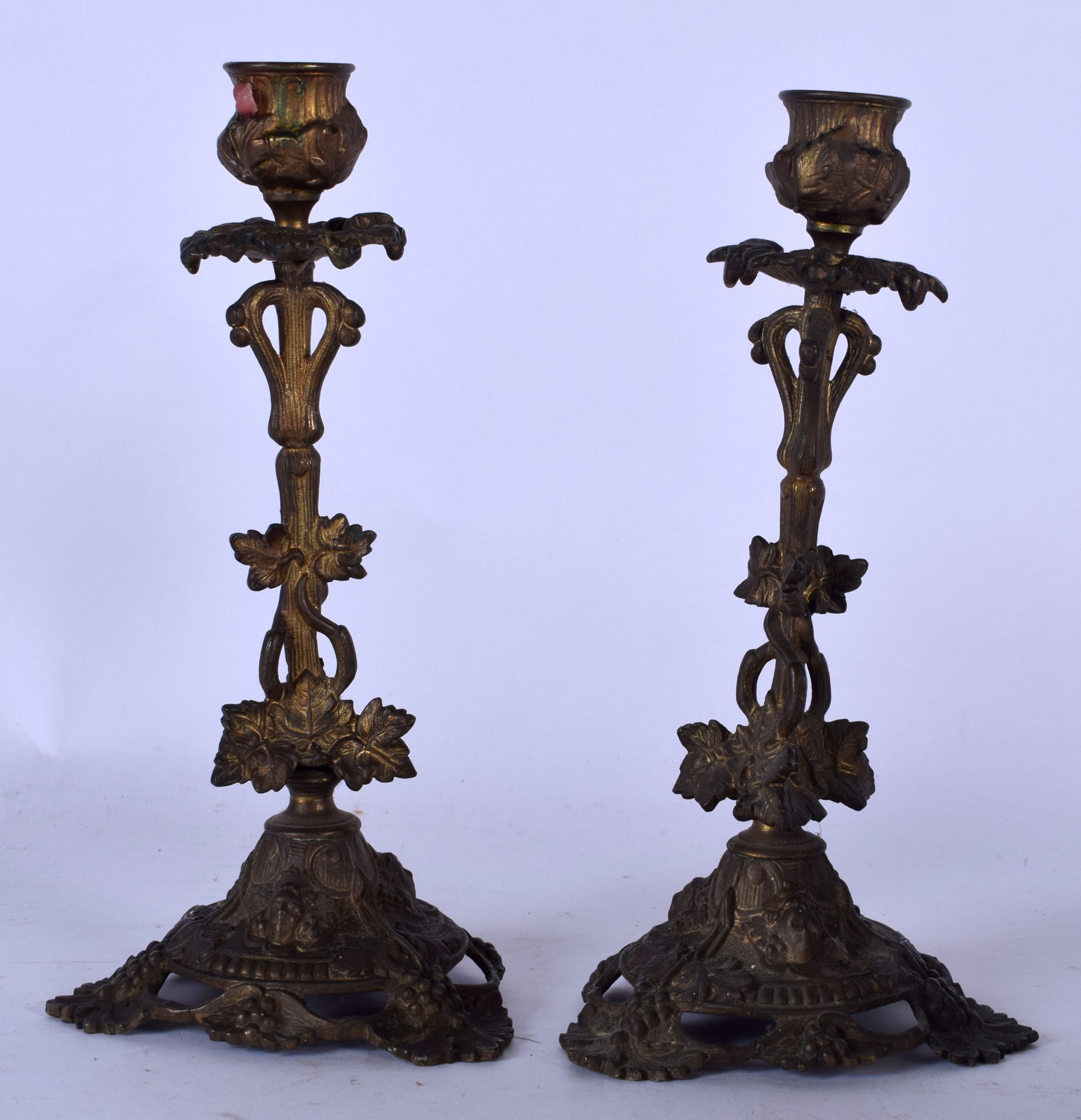 A PAIR OF BRONZE CANDLESTICKS, the feet in the form of fruiting vines. 23 cm high.