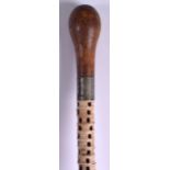 A 19TH CENTURY CONTINENTAL CARVED WHALE VERTEBRAE WALKING CANE with large turned wood terminal. 85