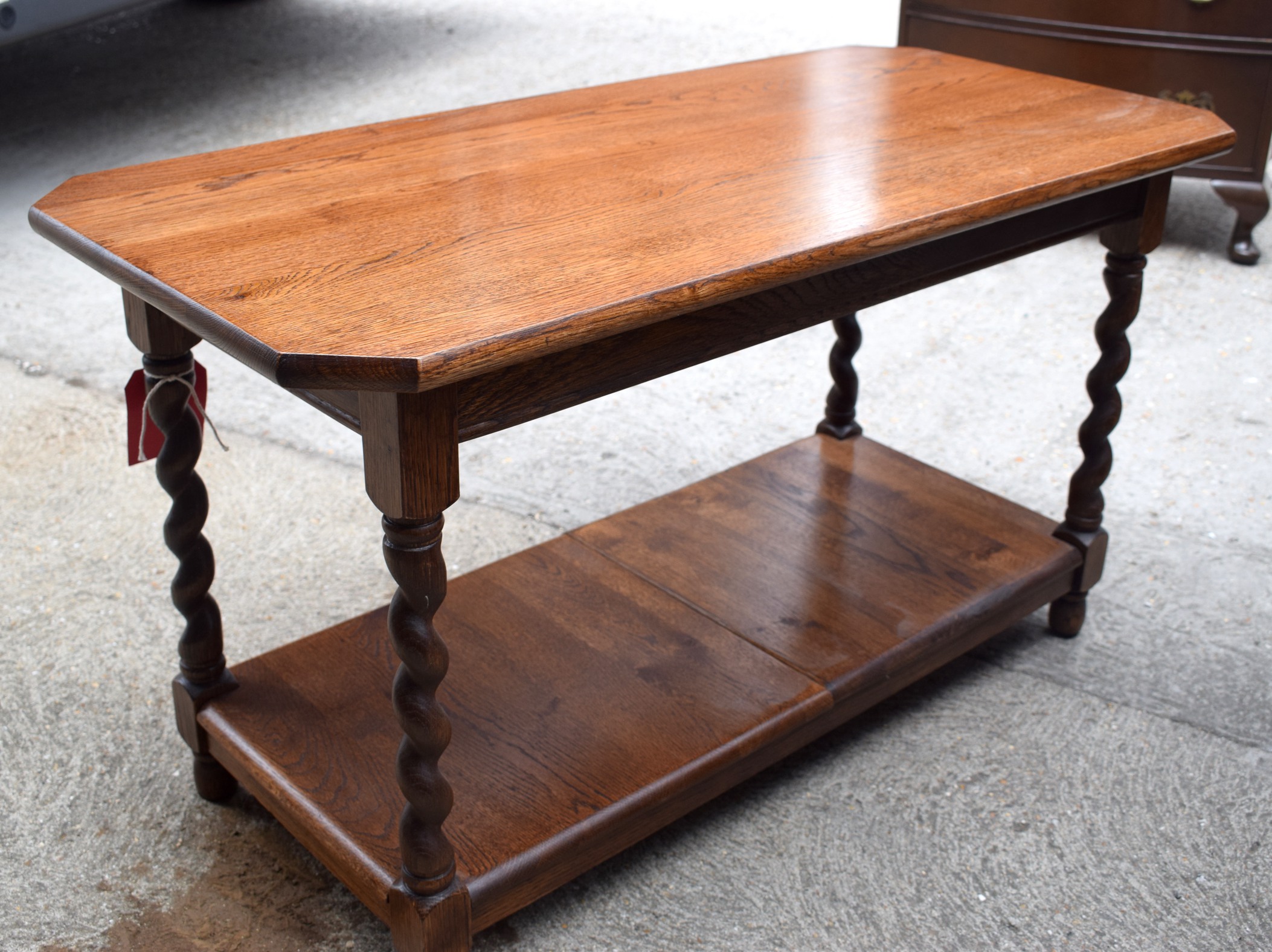 AN EARLY 20TH CENTURY OAK TWO TIER COFFEE TABLE, formed with carved twist supports. 51 cm x 90 cm.