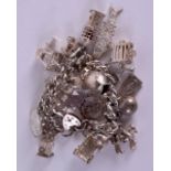 A HEAVY VINTAGE SILVER CHARM BRACELET formed with various coins, jugs etc. 6 oz.