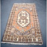 A SMALL BEIGE GROUND PERSIAN RUG, decorated with symbols and foliage. 183 cm x 109 cm.