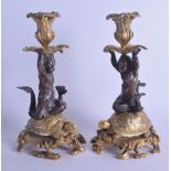 A PAIR OF MID 19TH CENTURY FRENCH BRONZE AND ORMOLU CANDLESTICKS modelled as putti resting upon