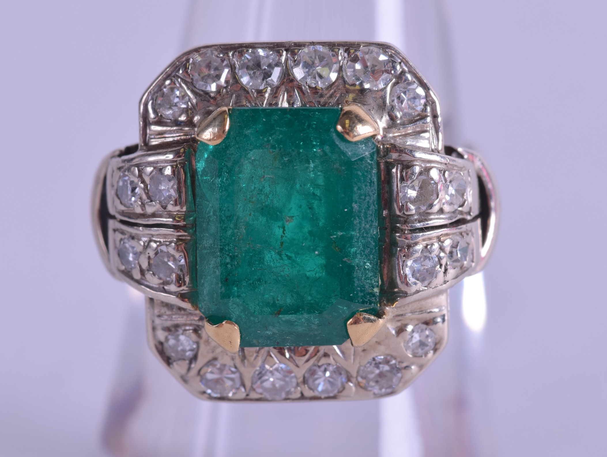 A GOOD 1930S WHITE GOLD EMERALD AND DIAMOND RING of stylish form. Size L.