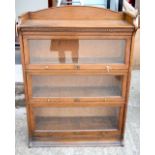 A LEBUS THREE TIER SECTIONAL BOOKCASE, raised on a block plinth with brass knob handles. 123 cm x 88