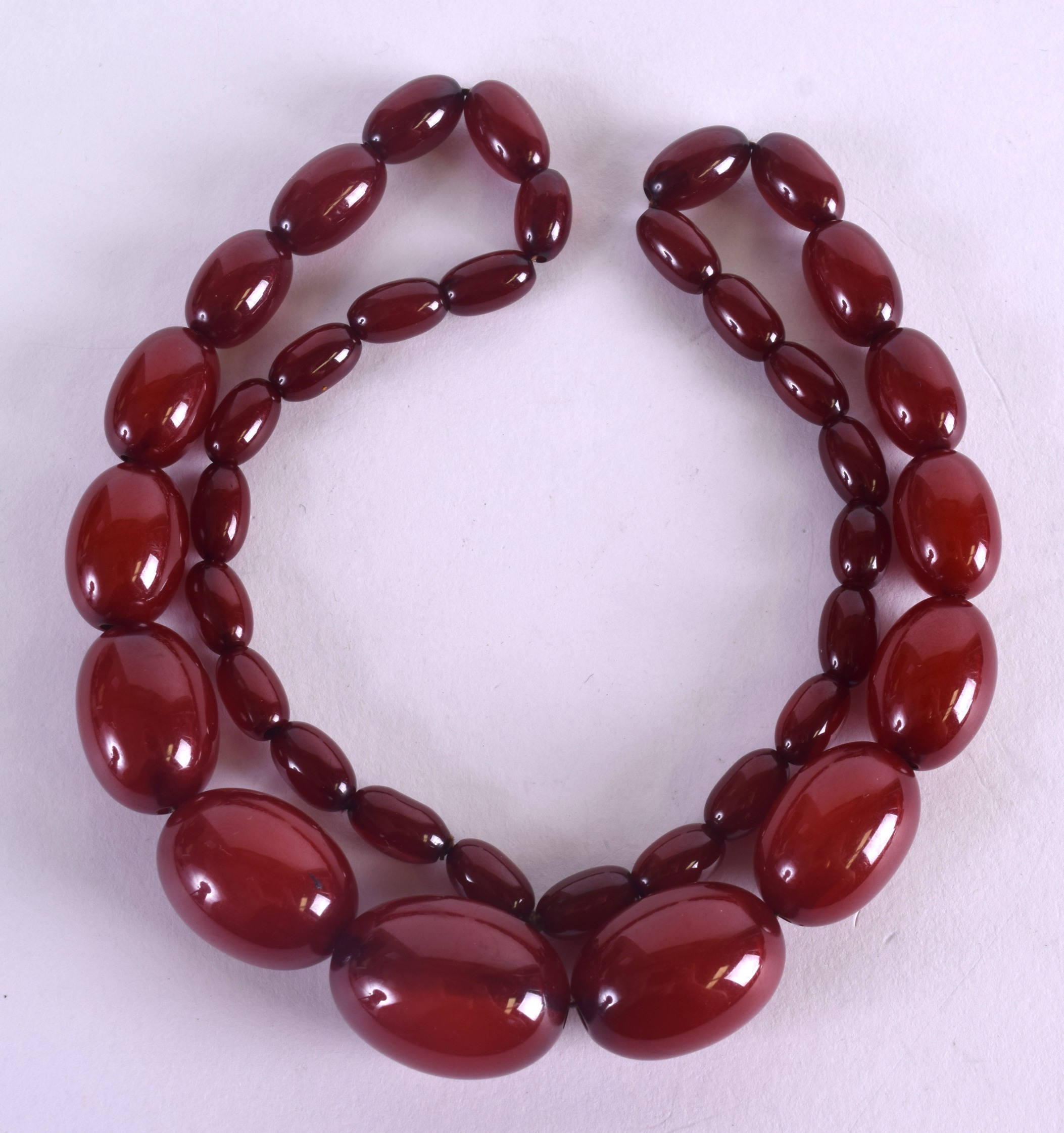 A 1930S CARVED CHERRY AMBER NECKLACE. 66 grams. 48 cm long.