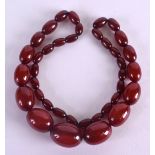 A 1930S CARVED CHERRY AMBER NECKLACE. 66 grams. 48 cm long.