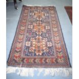 A BLUE GROUND TRIPLE MEDALION TRIBAL RUG, with extensive decoration. 198 cm x 107 cm.