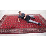 A DEEP RED GROUND TURKMEN YOMUT CARPET RUG, decorated with motifs. 334 cm x 204 cm.