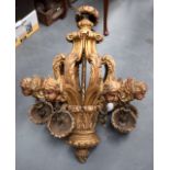 A LARGE GILTWOOD CHANDELIER, decorated with cherub mask heads. 90 cm long.