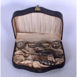 A CASED WHITE METAL DRESSING SET, containing various utensils.