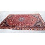 A RED GROUND PERSIAN SHIRAZ RUG, extensive decoration depicting animals and symbols. 300 cm x 204